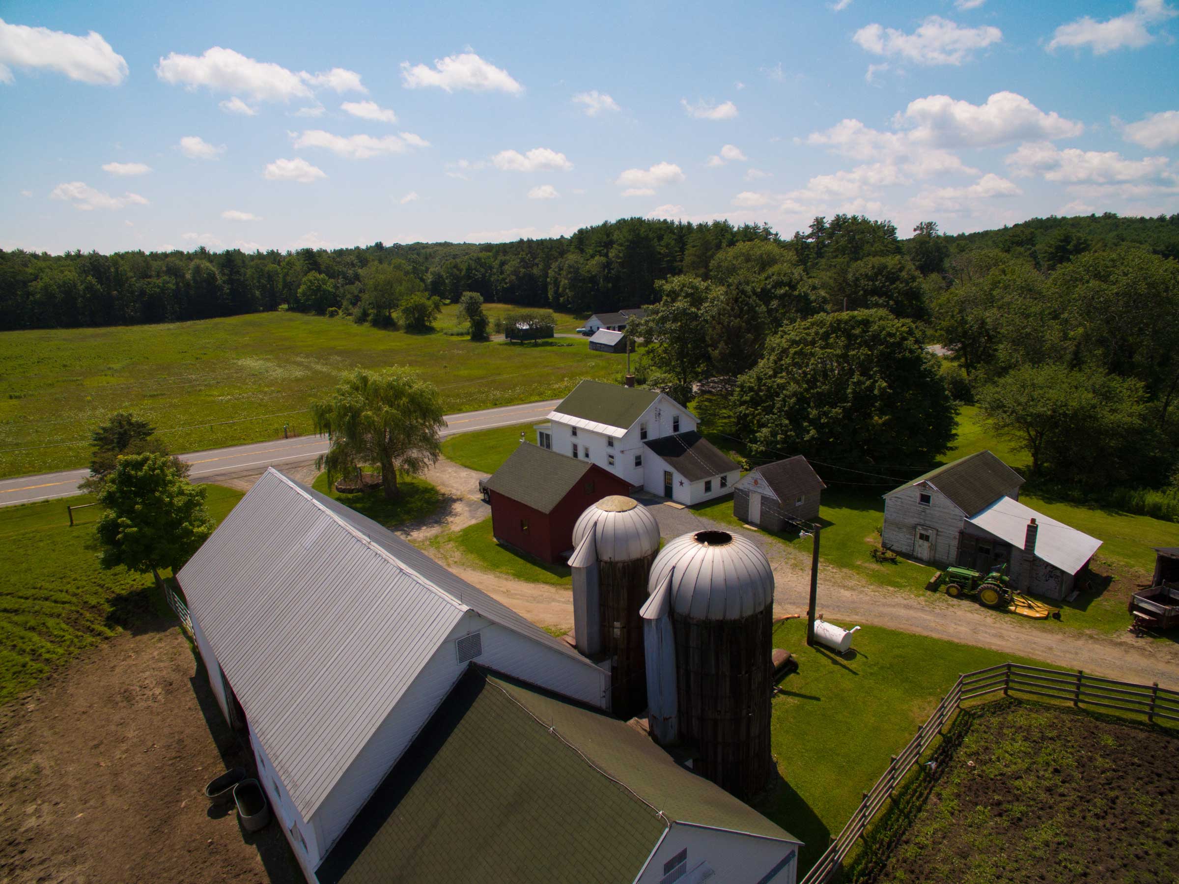 Aerial photo overlooking barn, silos and house at property in Mayfield, New York.