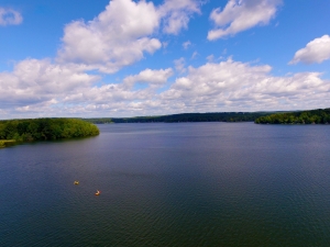 Aerial photo of Galway Lake with dramatic clouds in the sky and two canoes in the foreground.