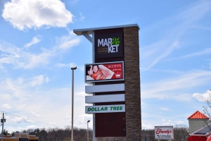 Photo of Market 32 by Price Chopper sign in front of Clifton Park shopping center with Scott's Hallmark animated video advertisement by SillyCar Design showing on the video screen.