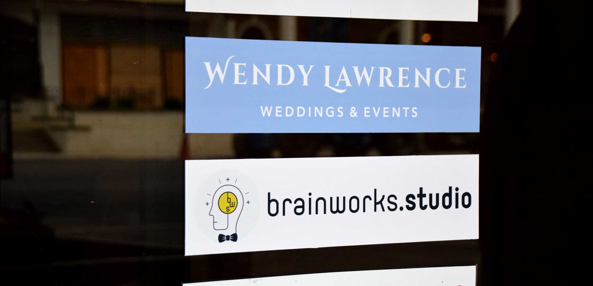 Photo of glass door signage for Wendy Lawrence Weddings & Events and Brainworks Studio.